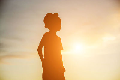 Silhouette man standing against sky during sunset