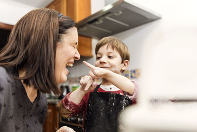 Mother and son laughing while cooking together