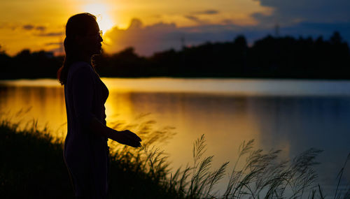 Silhouette of a woman on the lake with sunset