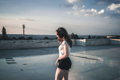 Woman standing on terrace against sky