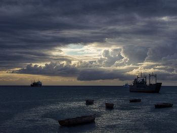 Boat sailing in sea against sky during sunset