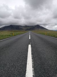 Surface level of road against cloudy sky