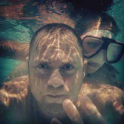 Portrait of young man swimming in pool