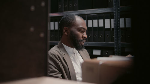 Side view of man looking away while standing in office
