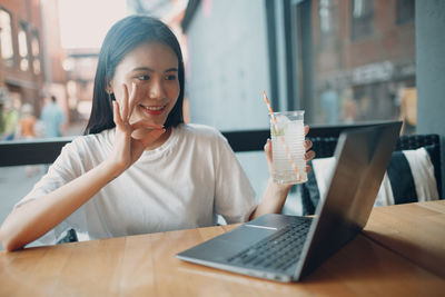 Young woman using mobile phone in restaurant