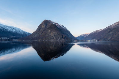 Scenic view of lake and mountains against blue sky