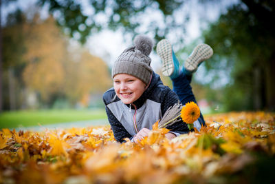 Smiling boy with autumn leaves