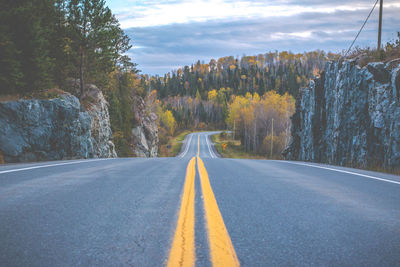 Road amidst trees against sky