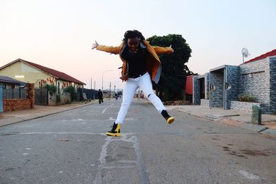 Rear view of woman jumping on street of soweto