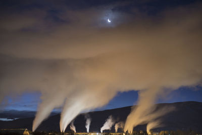 Low angle view of smoke emitting from chimney at dusk