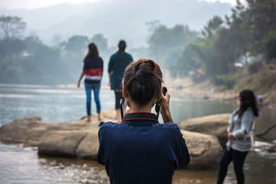 Rear view of people standing on beach