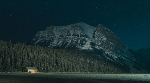 Scenic view of illuminated mountains against sky at night