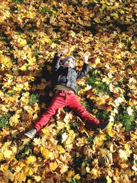 High angle view of woman lying down on ground during autumn