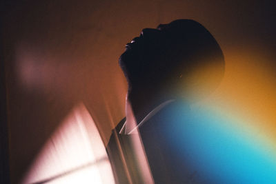 Close-up portrait of silhouette woman against wall