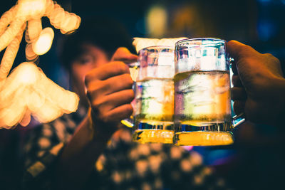Close-up of hands holding beer glass