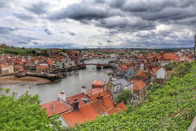 High angle view of townscape by river against sky