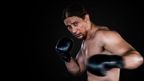 Midsection of man making face against black background