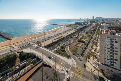 High angle view of city by sea against sky