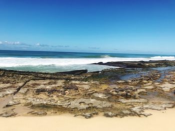 Scenic view of beach against blue sky