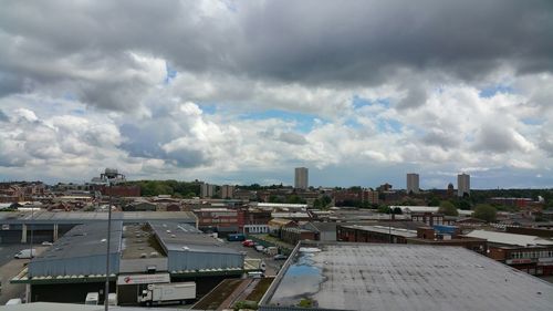 View of cityscape against cloudy sky