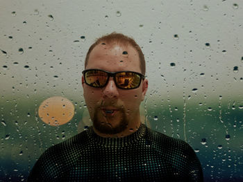 Portrait of smiling woman in wet glass