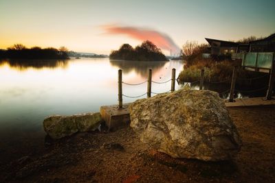 Scenic view of lake against sky at sunset