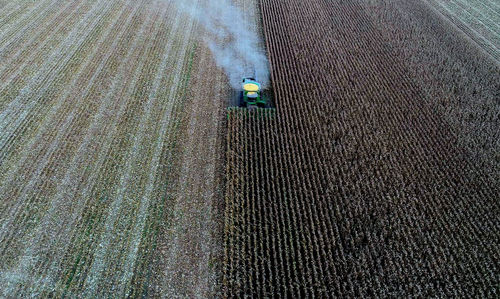 Aerial view of combine harvester harvesting crops at farm