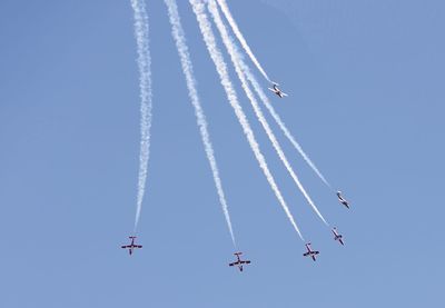 Low angle view of airplanes flying in sky