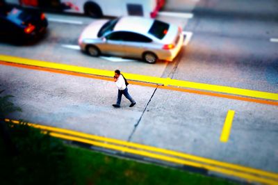 Full length of yellow crossing road