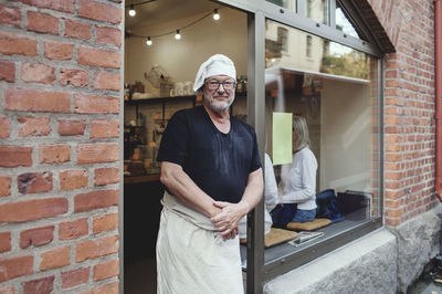 Portrait of senior male baker standing at bakery