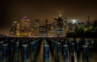 Illuminated cityscape against sky at night