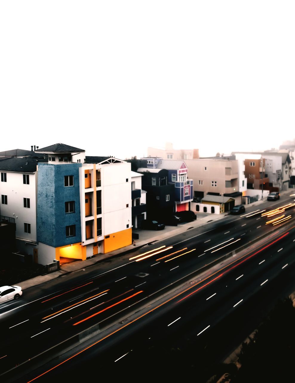 transportation, building exterior, architecture, built structure, road, speed, motion, no people, land vehicle, outdoors, clear sky, illuminated, city, high street, sky, day