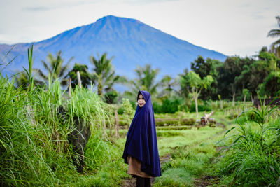 Woman standing on field against mountain