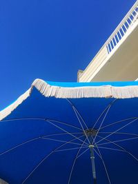 Low angle view of parasol against clear sky