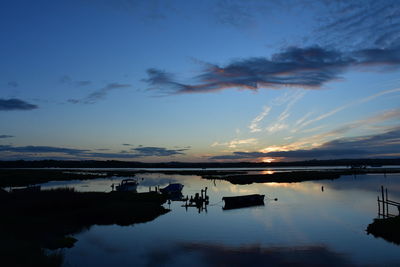 Scenic view of harbour against sky at sunrise 