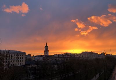 Buildings in city against sky during sunset