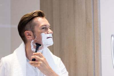 Man shaving in bathroom