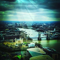 Bridge over river against cloudy sky