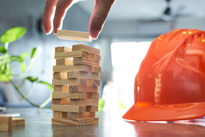 Cropped image of female architect stacking wooden blocks on table