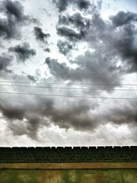 Low angle view of birds flying over cloudy sky