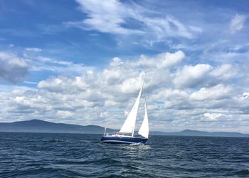 Sailboat in sea against blue sky