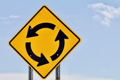 Low angle view of road sign against sky