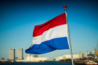 Low angle view of flag against blue sky