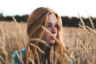 Close-up portrait of young woman in field