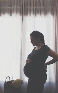 Pregnant woman standing by window