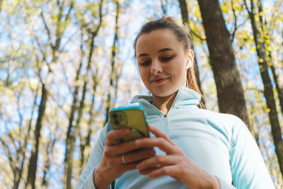 Beautiful girl uses phone for fitness or yoga.