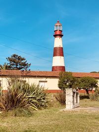 Lighthouse on field against sky