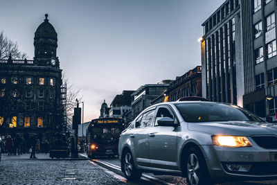 Cars on street against buildings in city