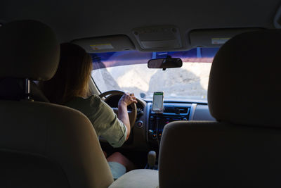 Woman driving with the gps directions on her phone