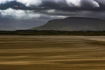 Scenic view of mountains against cloudy sky